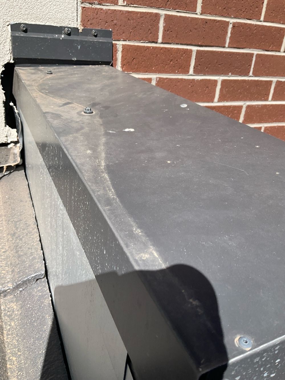Capping fixed from above instead of the sides, inviting leaks at each screw, found during a pre-handover inspection in Werribee